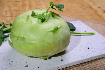Fresh green kohlrabi with green leaves ready to eat from the garden, new harvest