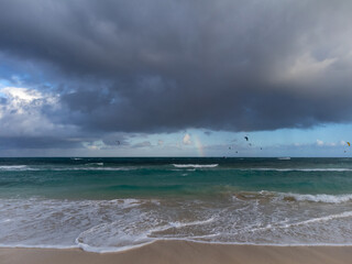 Fototapeta na wymiar View on white sandy Corallejo beach, Atlantic ocean water and kite surfers at winter