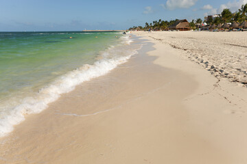 Tranquil sandy beach with crashing waves embodies vacation's essence of relaxation and escape from daily routine. A symbol of rejuvenation and freedom