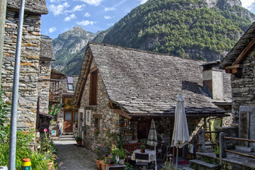 Fototapeta na wymiar stone houses with geraniums on balconies in Sonogno, now Verzasca, Ticino canton, Switzerland