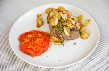 A mouth-watering steak dinner with tomato and garlic represents a balance of indulgence and healthy nourishment. Symbolizing strength, vitality, and a celebration of life
