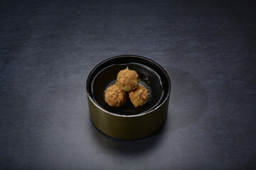 mini bake luxury tart in Japanese hojicha crisp with cranberry pineapple jam paste inside with clove stick and black plate gold fork knife on dark background pastry dessert halal party food menu