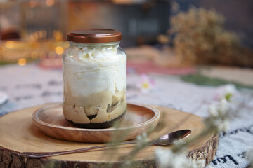 Banoffee cake in a bottle on a plate lined with a wooden tray