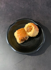 mini bake luxury tart in Japanese hojicha crisp with cranberry pineapple jam paste inside with clove stick and black plate gold fork knife on dark background pastry dessert halal party food menu