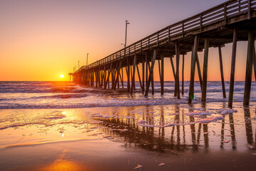 Fototapeta na wymiar Venerable wood fishing pier in Virginia Beach at sunrise.