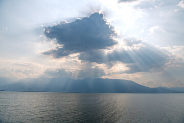 The sunset sun rays over Erhai lake in Shuanglang, Dali, China. Copy space for text, background