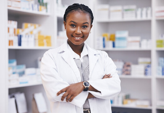 Pharmacy, pharmacist or portrait of black woman with arms crossed or smile in healthcare drugstore or clinic. Face, hospital or happy doctor smiling by medication or medicine on shelf ready to help