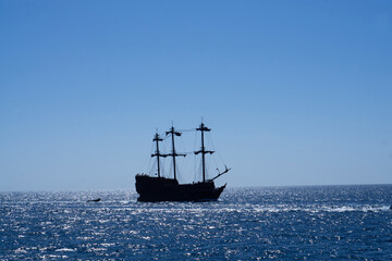 Obraz na płótnie Canvas Old ancient pirate ship on peaceful ocean at sunny day. Pirate ship at the open sea with copy space and selective focus in Egypt red sea.