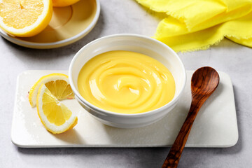 Homemade vanilla custard pudding or lemon curd in a white bowl.