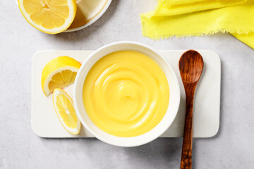 Homemade vanilla custard pudding or lemon curd in a white bowl. top view