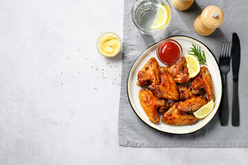 Air fryer chicken wings glazed with hot chili sauce and served with different sauces. Light gray  background . top view - 595462229