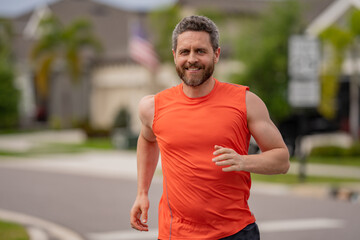 Fototapeta premium Running man sprinting workout outdoor. Fit athlete man running on american neighborhood.