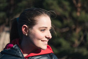 Portrait of a blue-eyed young woman smiling in nature