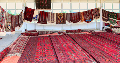 Pavilion selling Turkmen handmade carpets. Handmade carpets with traditional ornament. Turkmenistan. Ashkhabad market. - 595476435