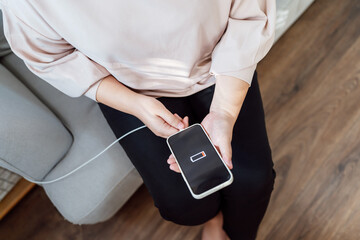 Woman hands Charging mobile phone battery with low battery. plugging a charger in a smart phone  with energy bank powerbank power charger Modern lifestyle energy technology concept