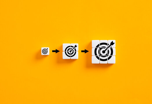Setting business goals. Developing goals and objectives. Growing target symbols on white cubes on yellow background.