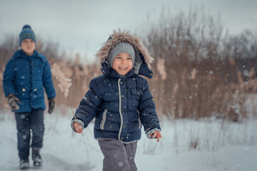 Boys run and laughing in snow forest.