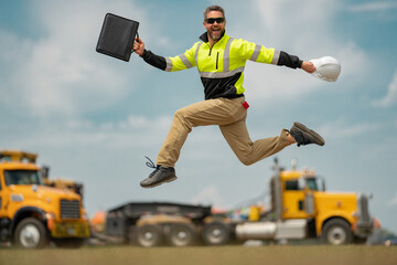 Bilder excited jump in hardhat. Construction man with helmet. Industry worker at construction...