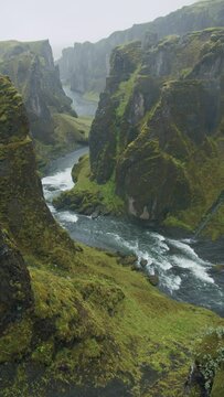 Fjadrargljufur canyon by heavy rain weather Bizarre steep cliff rock formations and winding river in the valley Iceland, Europe