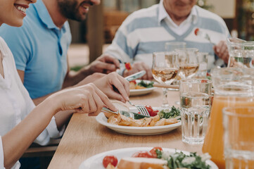 Close-up of happy multi-generation family enjoying dinner while sitting outdoors together