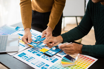 UI designer and UX developer team designer brainstorming about mobile app interface wireframe...