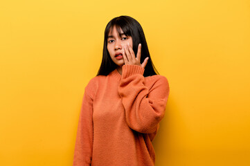 Cute Asian girl smiling on yellow background. Empty, young woman. Place for advertisement. copy space