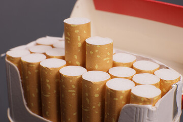 Open pack of cigarettes on a gray background