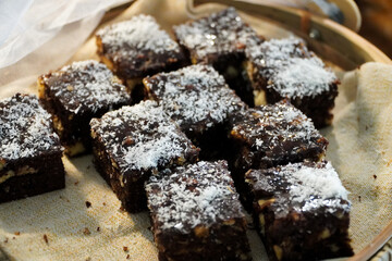 Chocolate brownies with icing sugar on a wooden table