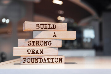 Wooden blocks with words 'Build a strong team foundation'. Business concept