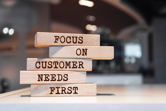 Wooden blocks with words 'Focus on customer needs first'. Business concept