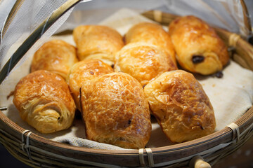 Freshly baked croissants with raisins in a basket