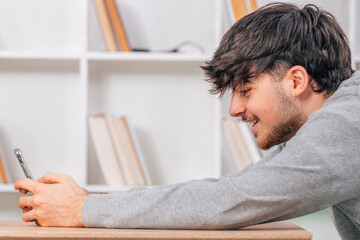 Fototapeta premium student with mobile phone or smartphone at desk