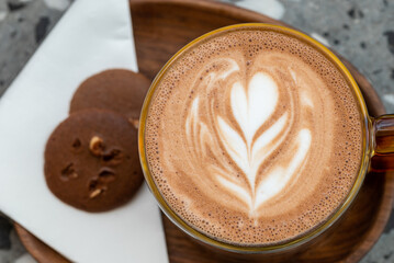 Cup of cappuccino with latte art with two chocolate biscuit top view - 595500832