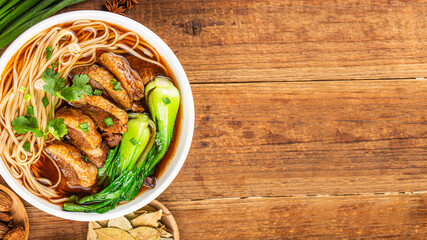 Spicy red soup beef noodle in a bowl on wooden table