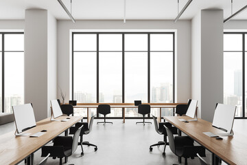 Cozy business room interior with coworking zone with computers, panoramic window