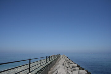 Fototapeta premium 四国の快晴の日の海へと続く道とテトラポット