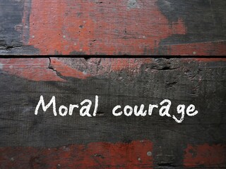 Grunge vintage wall with handwritten text MORAL COURAGE, means courage to take action for moral...