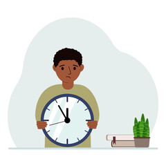 A little boy is holding a big clock in her hands. The concept of planning, organization of education, effective study.