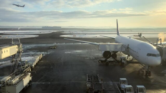 氷点下の駐機場　背後に飛び立つ飛行機　フレームインからフレームアウト