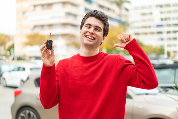 Young handsome man with car key proud and self-satisfied