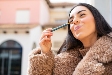 Young woman holding a pen at outdoors