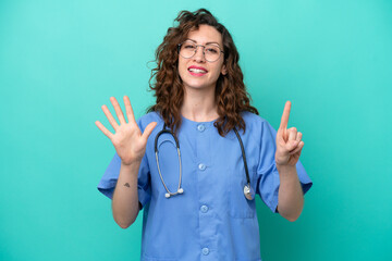 Young nurse caucasian woman isolated on blue background counting six with fingers