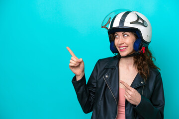 Young caucasian woman with a motorcycle helmet isolated on blue background intending to realizes the solution while lifting a finger up