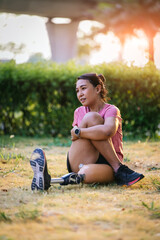 Athlete with prosthetic leg doing warm up exercise on park. Woman wearing prosthetic equipment  for jogging. Female with prosthesis of leg