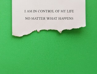 Fototapeta premium Handwritten torn note on green background - I am in control of my life no matter what happens - positive self talk affirmation to reaffirm control of your life and move forward with confident