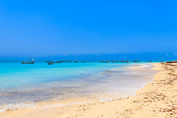 View of tropical sandy Nungwi beach and traditional wooden dhow boats in the Indian ocean on Zanzibar, Tanzania