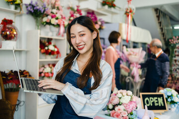 Young  female Owner Of Florists Shop With Laptop Talking On Mobile Phone.Asia woman vlogger influencer or SME owner people smile work on home video camera selfie .