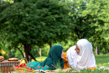 Portrait of happy religious enjoy happy love asian islam family muslim mother and little muslim girls child with hijab dress smiling and having fun moments good time in summer park