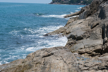Fototapeta na wymiar waves of the blue sea crash against the rocks