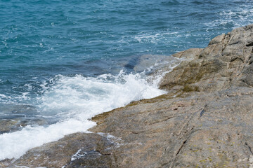waves of the blue sea crash against the rocks